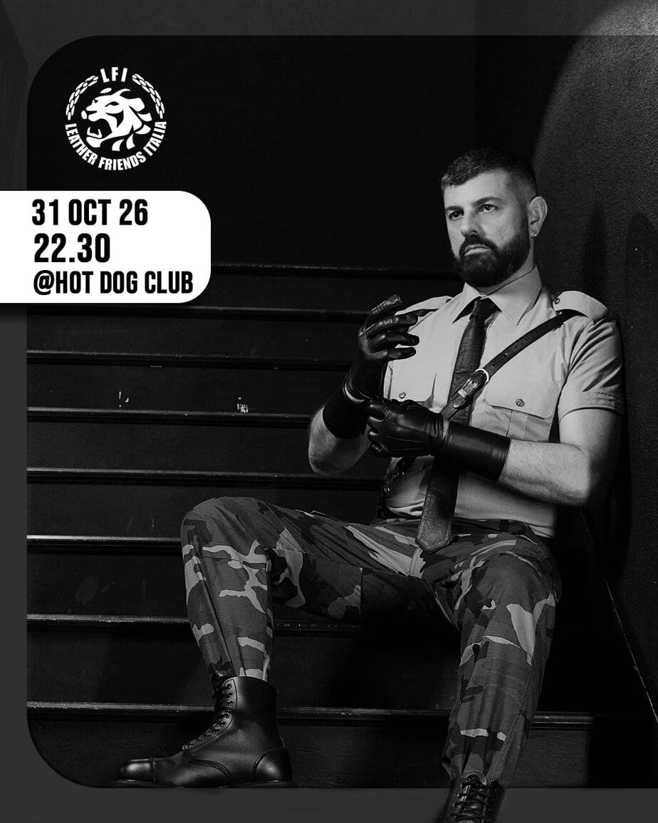 Uomo in abiti militari seduto sulle scale in un bar gay a Milano.